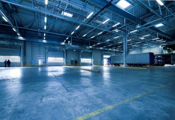 pexels photo 257636 257636 Wide view of an empty modern warehouse with industrial lighting and trucks.